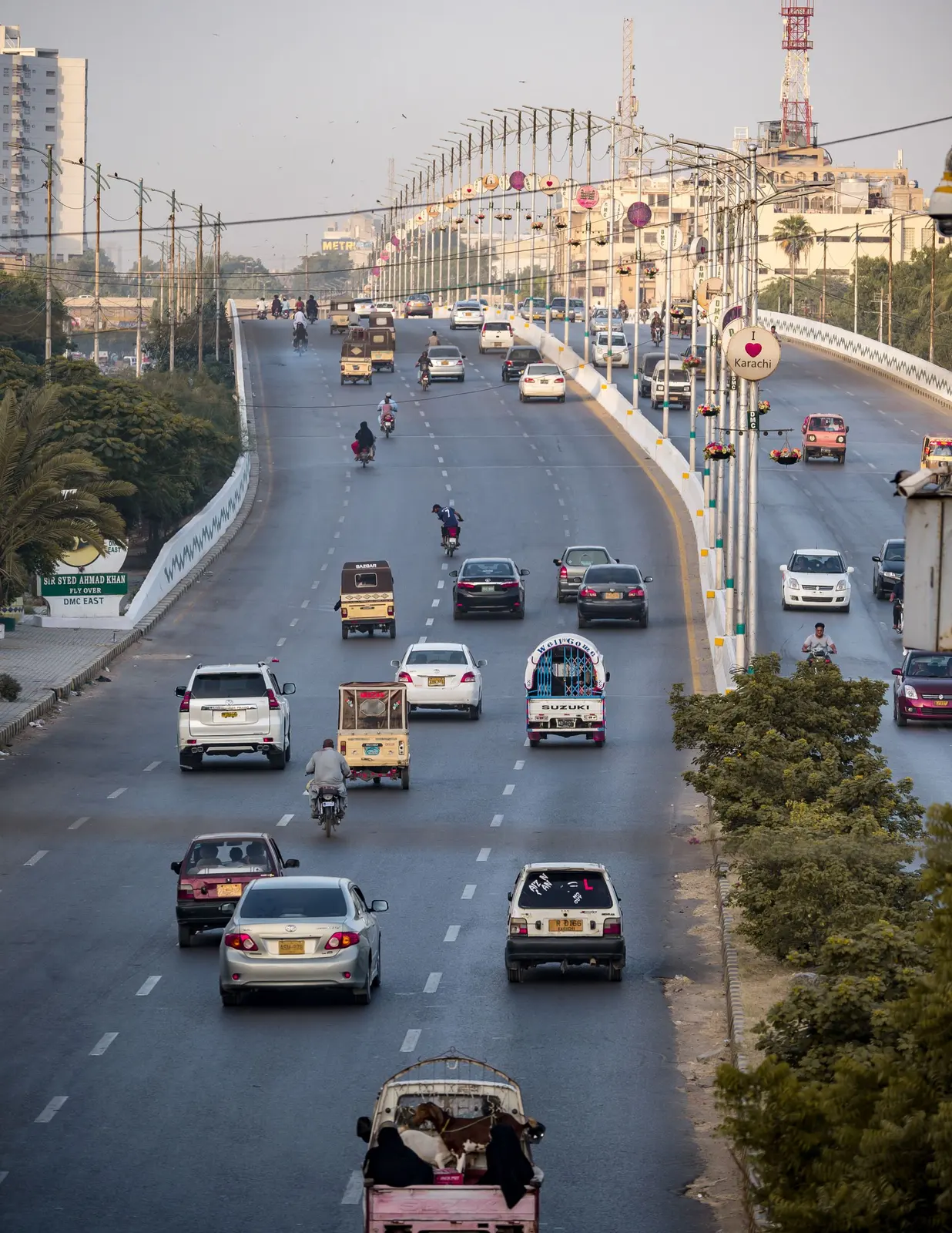 Cars, rickshaws and bikes on a busy avenue in Karachi
