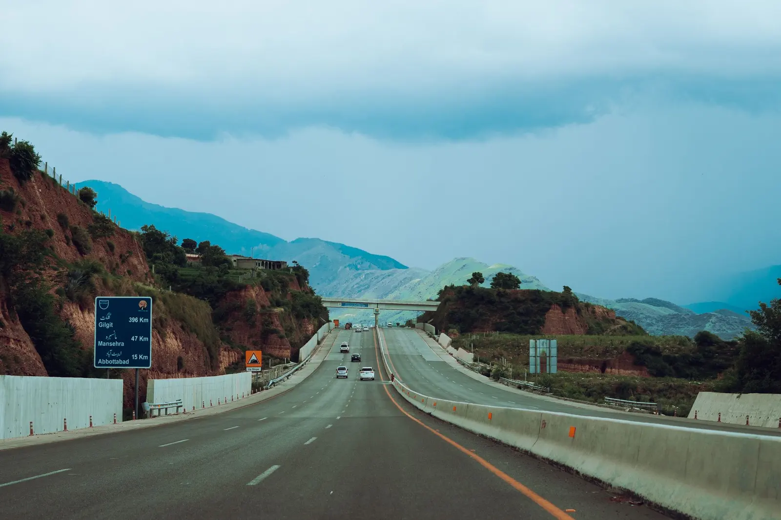A motorway running between green hills in Pakistan