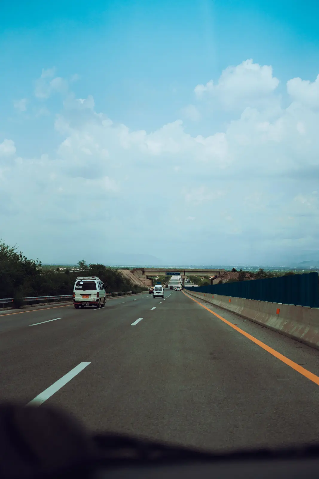 Cars travelling on a wide motorway under a blue sky