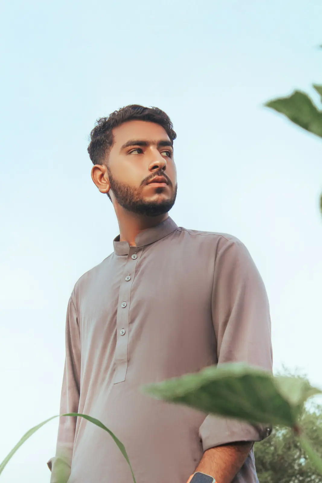 A young man in a shalwar kameez standing outdoors in Sadiqabad